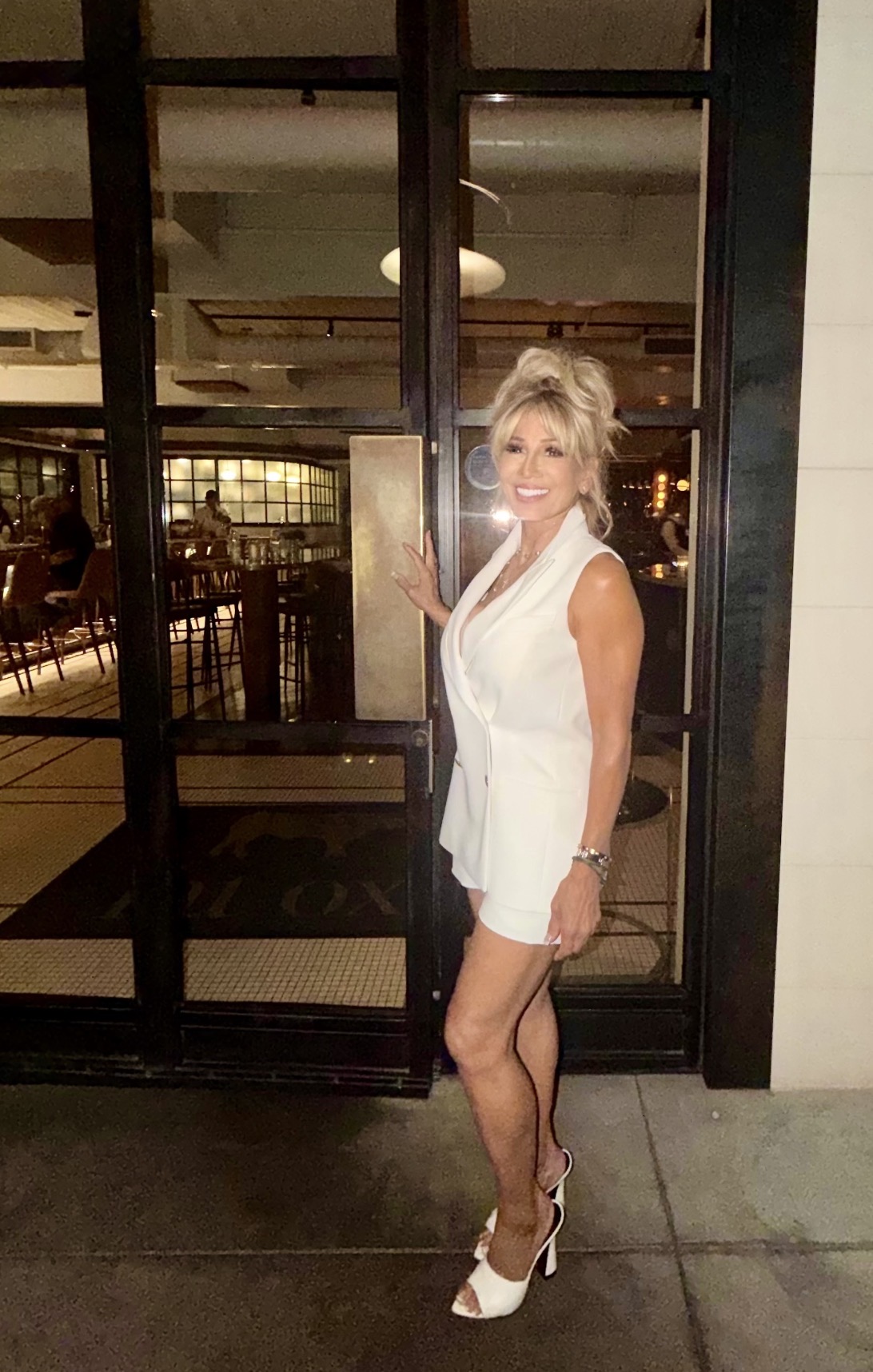 Kim Fisher in a white blazer, seated and smiling, the calm, held energy of The Ageless Reset room