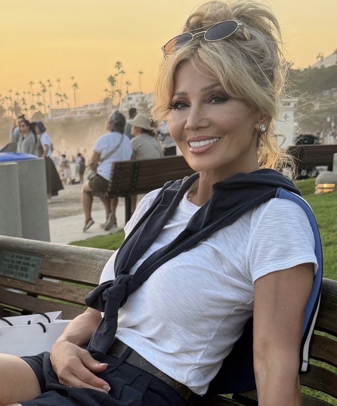 Kim Fisher on a bench at golden hour, relaxed and smiling