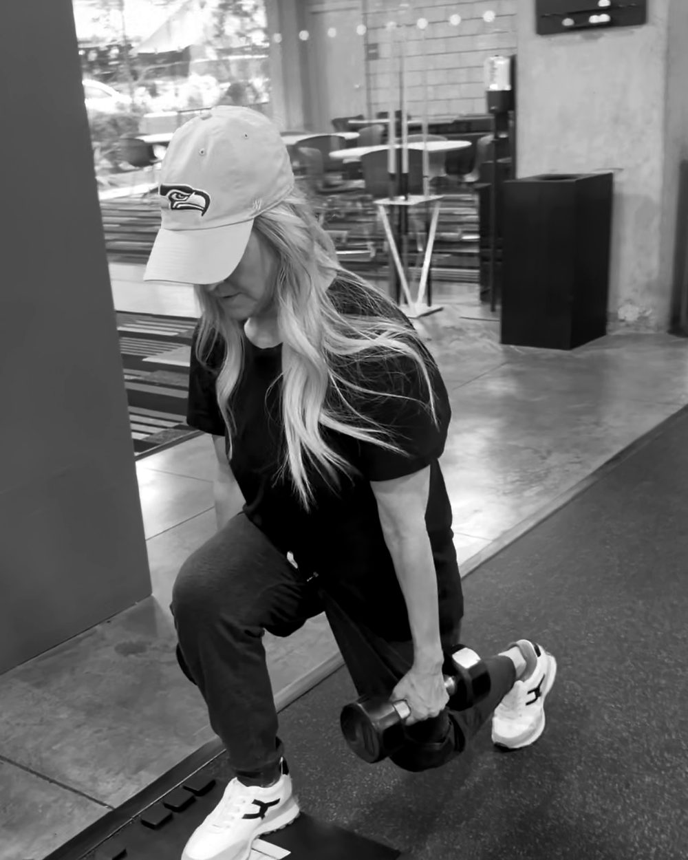 A Cohort 2 member doing a split squat with dumbbells at a pop-up session