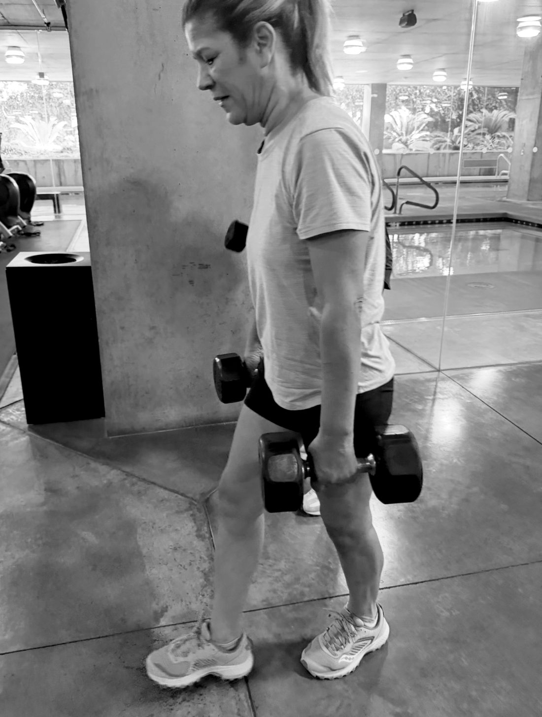 Michelle, 60, walking with a dumbbell in each hand at her six-month session